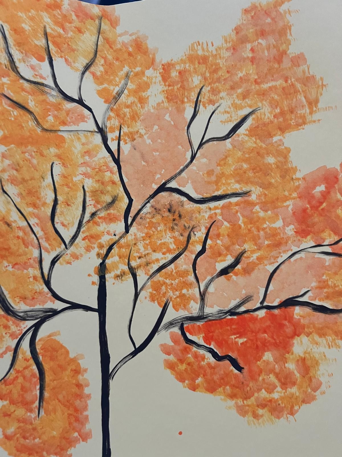 Dark branching limbs beneath a canopy of orange and golden leaves.