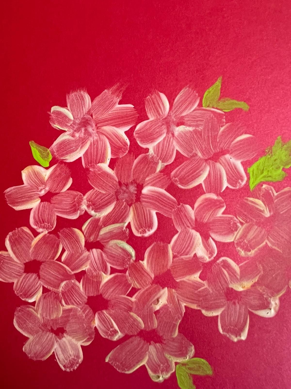 A cluster of small pink and white flowers with green leaves against a vivid red background.